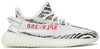 Adidas Yeezy Boost 350 V2 Zebra sneaker in white Primeknit with black stripes and red branding.