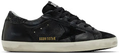 Golden Goose women’s Superstar sneaker with black leather upper, glitter heel tab, silver star, and distressed sole.