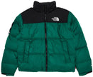 Main Product Shot: Model wearing the green Supreme x The North Face Nuptse puffer jacket outdoors.