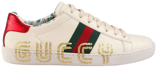 Gucci Wmns Ace Low sneaker in cream leather with “Guccy” side print and metallic heel detail.