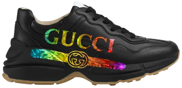 Gucci women’s Rhyton sneaker in black leather with iridescent Gucci logo and chunky rubber sole.

