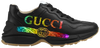 Gucci women’s Rhyton sneaker in black leather with iridescent Gucci logo and chunky rubber sole.

