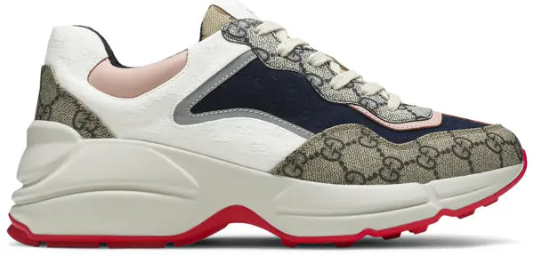 Gucci Wmns GG Rhyton sneaker in beige GG canvas with oversized pink and blue Gucci logo and chunky off-white sole.

