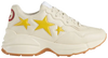 Gucci Wmns Rhyton 'Stars' sneaker featuring yellow star graphics on white vegan leather upper with ivory accents.

