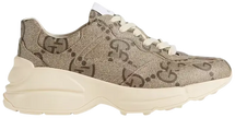 Gucci Wmns 100 Rhyton sneaker in beige and ebony GG monogram canvas with chunky rubber sole.

