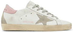 Golden Goose Superstar women’s sneaker in white leather with pink heel tab and distressed rubber sole.