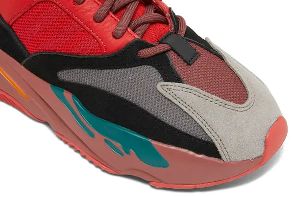 Yeezy Boost 700 ‘Hi-Res Red’ sneaker with red mesh and suede upper, maroon Boost midsole, and multicolor accents.